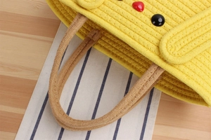 Detail of yellow woven cotton handbag showing textured knit patterns and colorful buttons