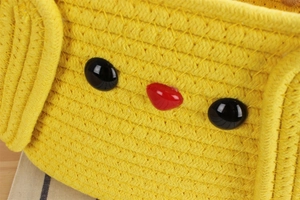 Close-up of yellow woven cotton tote with cute cartoon face beads and thick rope texture