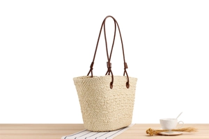 Close-up of cream woven tote bag with dark brown straps for summer beach holidays