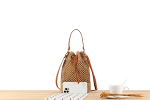Detail of woven straw bucket bag with leather drawstring and natural plant fiber texture