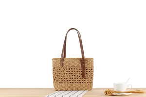 Detail of paper rope woven tote with brown leather straps and summer lifestyle decor