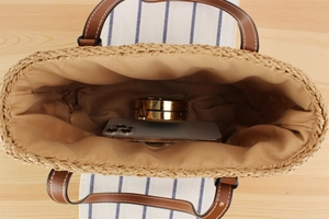 Top view of straw woven tote interior with leather handles showing large capacity