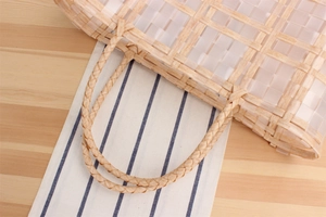 Close-up of a woven lattice tote bag featuring braided handles and natural wood grain texture
