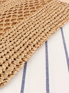 Hollow straw woven shoulder bag with diamond grid pattern on blue striped background