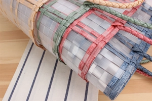 Detail of colorful woven tote bag showing durable plastic texture and mixed color patterns