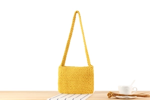 Detail of hand-woven cotton rope shoulder bag in ginger yellow with compact texture