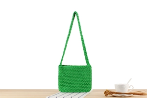Detail of green hand-woven cotton shoulder bag with dense geometric crochet texture