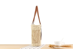 Détail du sac cabas tissé en corde de papier avec bandoulière en cuir sur bois