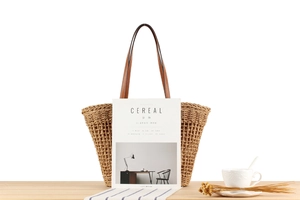 Détail du sac en corde de papier tressée avec anse en cuir marron posé sur une table