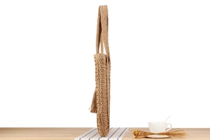 Detailansicht der großen Stroh-Tote-Bag mit dicker Textur und Fransen-Quasten-Anhänger