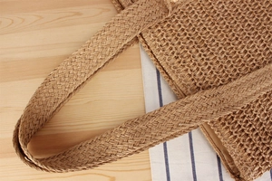 Detail der gewebten Strohtasche Griffe und Textur auf natürlichem Holzuntergrund