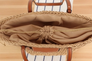 Vue détaillée du grand sac cabas en papier tressé avec poignées en cuir et doublure à cordon