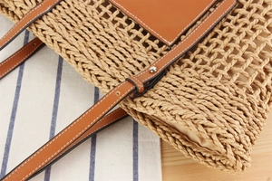 Gros plan sur le sac en papier tissé avec poche en cuir brun et boucle en métal
