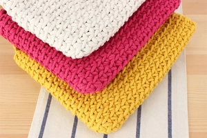 Detail of woven cotton rope shoulder bags showing dense cross-stitch texture and colors