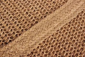 Nahaufnahme der Textur aus Naturpapier-Strohgeflecht und Trageriemen einer Tragetasche