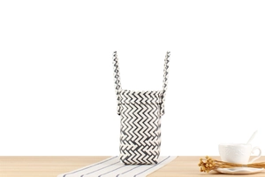 Detail view of woven plastic storage basket with black and white zigzag geometric patterns