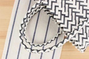 Detail shot of black and white checkered woven tote bag texture and top handle