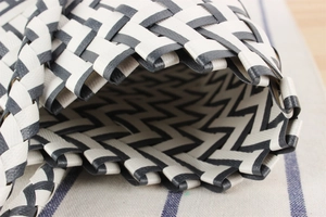 Macro detail of hand-woven plastic stripes with a black and white wave pattern