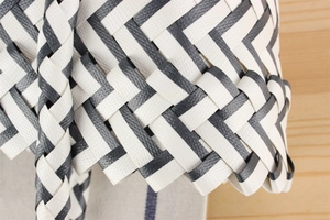Close-up of blue and white striped handwoven plastic storage basket with texture detail
