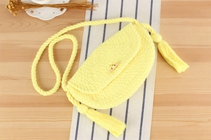 Vue détaillée du sac en corde de coton jaune avec pompons et bandoulière épaisse tressée