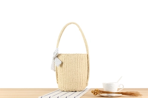 Detailaufnahme der geflochtenen Strandtasche mit gepunkteter Schleife und Textur