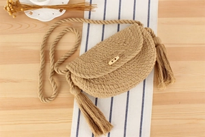 Vue détaillée de la texture en coton tressé avec pompons et bouton en bois de corne naturel