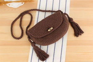 Détail d'un sac en corde de coton tissé main avec pompon et bouton en bois sur table