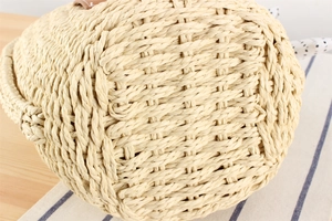 Detailansicht der Stroh-Eimertasche mit braunem Lederbesatz und gepunktetem Stoffakzent