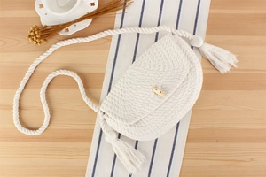 Détail du sac en coton tissé main avec glands décoratifs et fermeture à bouton en bois chic