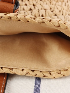 Minimalist large woven shoulder bag with brown leather handles and textured raffia finish