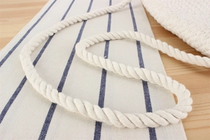 Gros plan sur la bandoulière en corde de coton blanc et la texture du sac crocheté