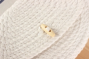 Détail de la texture en corde de coton tressée avec un fermoir en bois naturel