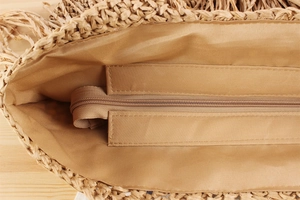 Detail der handgewebten Strohtasche mit braunem Satinfutter und Reißverschluss