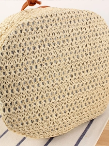 Minimalist beige woven straw bucket bag with brown leather trim for summer beach vacations