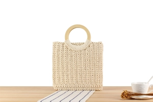 Detail of cream handmade woven tote with natural round wooden handles and textured knit