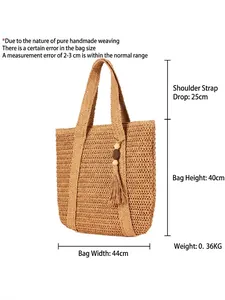 Große Strandtasche aus Papierstroh mit Quasten und Holzperlen vor weißem Hintergrund