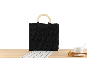 Close-up of black woven cotton tote bag with round wooden handles on a rustic table