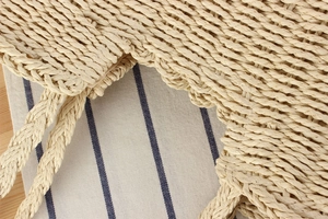 Détail du bord ondulé en corde de papier et de l'anse d'un sac de plage beige