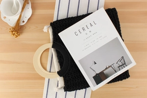 Detail view of black woven cotton tote bag with round wood handles and canvas lining