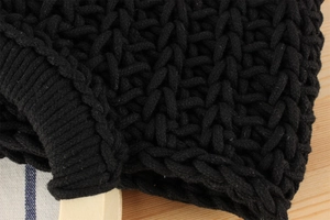Detailed macro shot of black cotton rope woven texture with smooth wooden handle detail