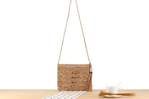 Détail d'un sac en paille fait main avec tissage ondulé ajouré et longues franges