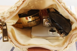 Detail view of woven paper rope bag interior showing capacity for phone and cosmetics