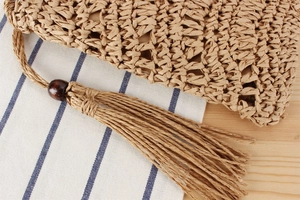 Détail d'un sac de plage tressé à la main avec de longs glands et une perle en bois