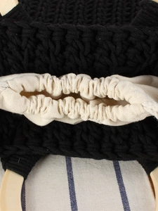 Handmade black crochet handbag with smooth wooden handle and canvas drawstring liner