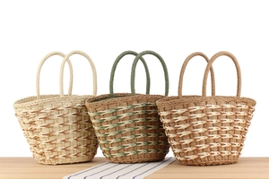 Detailed view of three handmade woven tote bags in beige, green, and caramel colors