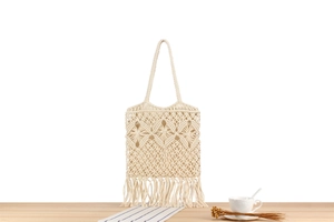 Detailed macro view of bohemian handmade macrame weave and long tassels on cotton tote bag