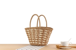 Close-up of diamond pattern woven tote bag with round handles on a wooden table