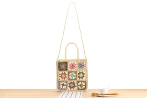 Detail of colorful crochet flower patterns on a handmade bohemian woven crossbody bag