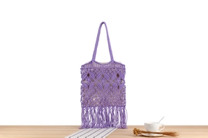 Close-up of purple handmade woven tote bag with fringe detail and bohemian pattern