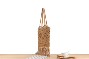 Detailed view of hand-woven bohemian cotton rope bag with elegant diamond texture and tassels